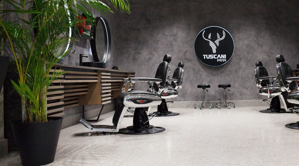 The barbering floor at Tuscani Man, with chairs and a round mirror